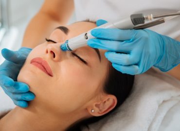 Facial procedure. Delighted nice woman lying on the medical bed with her eyes closed while having hydrafacial